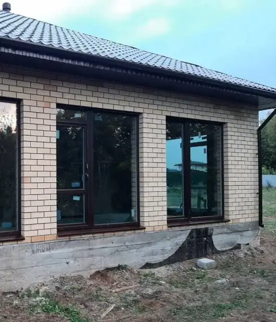 Окна и дверь на участок в частном доме из кирпича